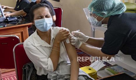 Seorang petugas kesehatan disuntik vaksin COVID-19 di pusat vaksinasi di Denpasar, Bali, Indonesia, 29 Januari 2021. Indonesia telah melaporkan lebih dari satu juta kasus COVID-19 sejak awal pandemi, jumlah tertinggi di Tenggara. Asia.