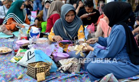 Warga memotong ketupat untuk dimakan bersama keluarga saat tradisi Lebaran Ketupat di Pantai Sanur, Denpasar, Bali, Rabu (17/4/2024). Tradisi lebaran ketupat yang dirayakan ribuan umat muslim di kawasan itu pada hari ketujuh setelah Hari Raya Idul Fitri dilakukan sebagai ajang untuk saling bersilaturahmi.