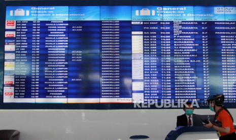 Petugas informasi bandara berada dibawah Monitor jadwal penerbangan di Terminal 3 Bandara Soekarno Hatta, Tangerang, Banten, Rabu (1/4/2020). Seluruh penerbangan komersial di Bandara Soekarno-Hatta dihentikan mulai 24 April hingga 1 Juni 2020.