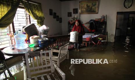 Warga membawa barang di dalam rumahnya yang terendam banjir di Kecamatan Medan Labuhan, Medan, Sumatera Utara, Sabtu (30/11/2024). Badan Penanggulangan Bencana Daerah (BPBD) Kota Medan mencatat sebanyak 7.699 rumah atau 8.751 kepala keluarga terdampak banjir akibat luapan sungai pada Rabu (27/11) yang disebabkan curah hujan tinggi. 