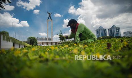 Pekerja beraktivitas di area Taman Lapangan Banteng dengan latar belakang lanskap langit berwarna biru di Jakarta, Rabu (2/12). Menurut Badan Meteorologi Klimatologi dan Geofisika (BMKG) Kondisi cuaca yang cerah diakibatkan kelembapan udara yang kering serta angin yang kencang sehingga menghambat pertumbuhan awan hujan dan menyebabkan langit berwarna biru. Republika/Thoudy Badai