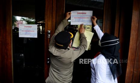 Petugas Satpol PP bersama Dinas Pariwisata dan Ekonomi Kreatif, serta TNI  melakukan penyegelan di salah satu bar-resto Holywings di Jakarta, Selasa (28/6/2022). Pemprov DKI Jakarta melalui Satuan Polisi Pamong Praja (Satpol PP) melakukan penutupan secara serentak terhadap 12 outlet perusahaan bar dan resto Holywings di Jakarta hari ini. Penutupan tersebut dilakukan setelah ditemukannya sejumlah pelanggaran diantaranya pelanggaran izin usaha atau belum memiliki sertifikat standar KBLI 56301 jenis usaha Bar yang telah terverifikasi. Republika/Thoudy Badai