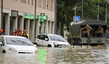 Petugas pemadam kebakaran dan tentara tiba di jalan yang dilanda banjir di desa Castel Bolognese, Italia, Rabu (17/5/2023). Hujan yang luar biasa pada hari Rabu di wilayah yang dilanda kekeringan di Italia utara membuat sungai meluap di tepiannya, menewaskan sedikitnya delapan orang, memaksa evakuasi ribuan orang dan mendorong para pejabat untuk memperingatkan bahwa Italia membutuhkan rencana nasional untuk memerangi banjir akibat perubahan iklim. 