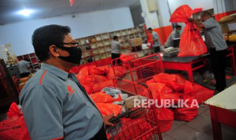 Karyawan dengan menggunakan masker menyortir barang paket kiriman di Kantor PT Pos Indonesia Cabang Jambi, Jambi, Senin (22/6/2020). Pemerintah menyebutkan, pembukaan kembali sembilan sektor ekonomi, termasuk di antaranya transportasi barang di tengah pandemi COVID-19 wajib menerapkan protokol kesehatan yang ketat. 