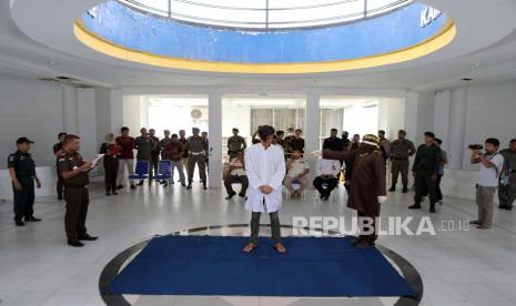  Seorang eksekutor dari Polisi Syariah yang dikenal sebagai Algojo mencambuk seorang pria karena melanggar hukum syariah, di Banda Aceh, 09 November 2022. Empat orang menerima hukuman cambuk dari 15 hingga 30 cambukan karena melanggar hukum syariah karena perjudian dan berhubungan seks pernikahan di luar. Aceh adalah satu-satunya provinsi di Indonesia yang menerapkan hukum syariah dan menganggap hubungan lesbian, gay, biseksual dan seks di luar nikah sebagai pelanggaran hukum.