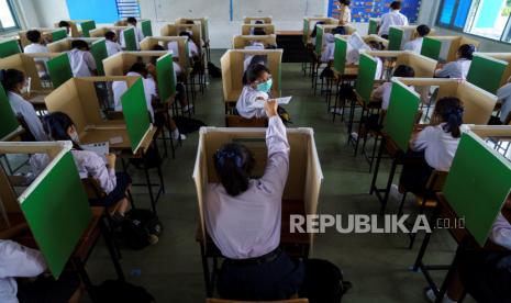 Siswa sekolah Sam Khok mengenakan masker wajah dan pelindung wajah duduk di dalam kotak suara tua yang dipecah menjadi beberapa partisi ketika mereka menghadiri kelas setelah pemerintah Thailand melonggarkan langkah-langkah isolasi dan memperkenalkan jarak sosial untuk mencegah penyebaran penyakit Covid-19.2020. 