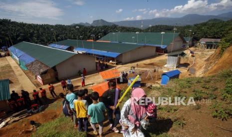 Pngungsi korban bencana banjir bandang dan longsor di Sukajaya berjalan di sekitar blok hunian sementara (Huntara) di Kabupaten Bogor, Jabar.