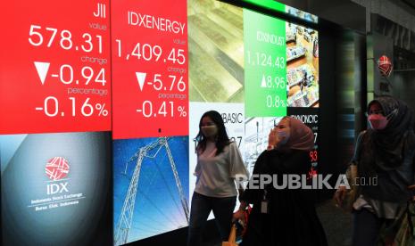 Pekerja melintas di depan layar indeks harga saham gabungan (IHSG) di Gedung Bursa Efek Indonesia.  Indeks Harga Saham Gabungan (IHSG) berakhir di zona negatif pada penutupan sesi pertama, Kamis (14/4). Setelah sempat dibuka menguat pada awal perdagangan, IHSG ditutup melemah sebesar 0,32 persen ke level 7.239,77. 