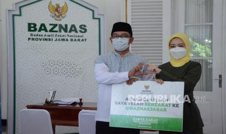 Gubernur Jawa Barat Ridwan Kamil (Emil) bersama Ketua TP PKK Atalia Praratya memperlihatkan simbol cinta zakat saat acara pembayaran zakat Gubernur Jawa Barat bertajuk Cinta Zakat Menyejahterakan Umat bersama Badan Amil Zakat Nasional (Baznas) di Gedung Pakuan, Kota Bandung, Selasa (12/4). Emil meminta kepada Baznas Jawa Barat untuk menginisiasi pengelola zakat lainnya untuk turut serta dalam membantu mengentaskan kemiskinan ekstrem di Jawa Barat.