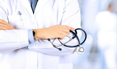 Portrait an unknown male doctor holding a stethoscope behind