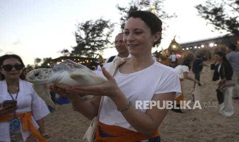 Seorang peserta membawa penyu untuk dilepasliarkan ke laut saat upacara ritual pemurnian air dalam World Water Forum ke-10 di Denpasar, Bali, Indonesia pada hari Sabtu, 18 Mei 2024