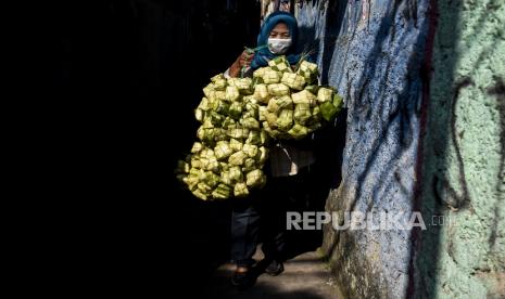 Seorang warga membawa kulit ketupat di Gang Blok Kupat, Babakan Ciparay, Kota Bandung, Selasa (11/5). Menjelang perayaan Hari Raya Idul Fitri 1442 Hijriah, permintaan kulit ketupat yang dijual dengan harga Rp10 ribu per 10 buahnya tersebut mengalami peningkatan hingga 50 persen dibandingkan Idul Fitri tahun lalu. 