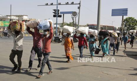 Buruh migran dari negara bagian lain yang mencoba untuk kembali ke rumah mereka berjalan menuju titik penjemputan untuk transportasi ke stasiun kereta api di Ahmedabad, India, Ahad, 17 Mei 2020. Puluhan ribu buruh migran telah kembali dari kota-kota besar ke desa mereka. setelah kehilangan pekerjaan karena kuncian di seluruh negeri yang diberlakukan pada akhir Maret untuk menahan penyebaran virus corona