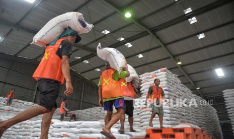 Pekerja mengakut beras di Kompleks pergudangan modern Perum BULOG, Kelapa Gading, Jakarta, Sabtu (30/12/2023). 