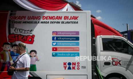 Warga berdiri di dekat mobil Simolek saat acara Edukasi Keuangan Bagi Masyakarat dan Peluncuran Mobil Simolek Edutainment Otoritas Jasa Keuangan (OJK) di Karanganyar, Jawa Tengah, Ahad (23/10/2022). OJK meluncurkan inisiatif Digital Financial Literacy (DFL) berupa gim Smart Digital Indonesia versi iOS yang dapat diunduh melalui Apple Store untuk meningkatkan literasi keuangan digital masyarakat. 