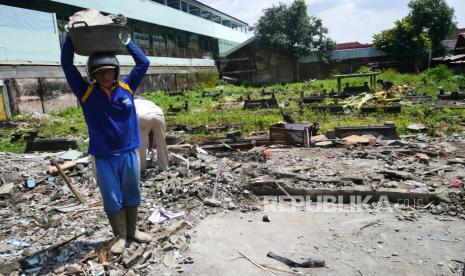 Pekerja membawa material bongkaran saat pembongkaran Makam Jopraban, Kemantren Wirobrajan, Yogyakarta, Rabu (8/12). Pemerintah Kota Yogyakarta alam mengalihfungsikan Makam Jopraban menjadi ruang terbuka hijau (RTH) publik dan fasilitas umum. Makam ini sudah ada 1985, menurut tokoh masyarakat selama 30 tahun terakhir ini tidak digunakan lagi untuk pemakaman.