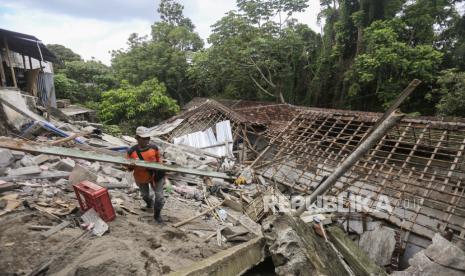 Relawan mengangkat kayu dari rumah tertimpa pohon tumbang (ilustrasi).