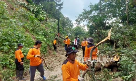 Proses pembersihan material longsor yang menutup akses jalan (ilustrasi)