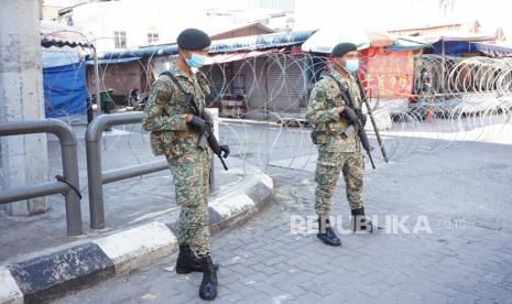 Petugas keamanan dari Angkatan Tentara Malaysia (ATM) bersiaga di Pasar Chow Kit, Kuala Lumpur, dengan latar belakang kawat berduri setelah kawasan tersebut ditetapkan menjadi Perintah Kawalan Pergerakan (PKP) Administratif, Selasa (5/5/2020). Pasar Chow Kit yang memiliki banyak penjual dan pekerja asal Indonesia menjadi kluster baru COVID-19 terbesar dengan 16 kasus dari penularan warga setempat