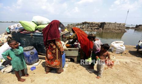 Para wanita mengumpulkan barang-barang yang diselamatkan dari rumah mereka yang terendam banjir setelah hujan monsun, di distrik Qambar Shahdadkot di Provinsi Sindh, Pakistan, Selasa, 6 September 2022. Lebih dari 1.300 orang tewas dan jutaan orang kehilangan rumah mereka akibat banjir yang disebabkan oleh banjir yang tidak biasa. hujan monsun lebat di Pakistan tahun ini yang banyak ahli telah menyalahkan perubahan iklim.