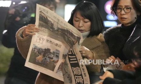 Orang-orang membaca edisi tambahan surat kabar Yomiuri Shimbun yang melaporkan gempa bumi Senin, 1 Januari 2024 di Tokyo. Jepang mengeluarkan peringatan tsunami dan memerintahkan evakuasi menyusul serangkaian gempa bumi pada hari Senin yang memicu kebakaran dan menjebak orang-orang di bawah reruntuhan di pantai barat pulau utamanya.