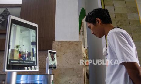 Calon penumpang melakukan scan wajah di Stasiun Yogyakarta, Senin (3/4/2023). PT Kereta Api Indonesia melakukan peningkatan layanan dengan menerapkan teknologi 