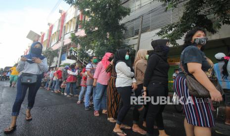 Pekerja mengantre masuk ke Pasar Kapasan Surabaya, Jawa Timur, Sabtu (18/4/2020). Perusahaan Daerah (PD) Pasar Surya Kota Surabaya membuka kembali pasar grosir itu setelah  selama 14 hari ditutup untuk memutus penyebaran COVID-19