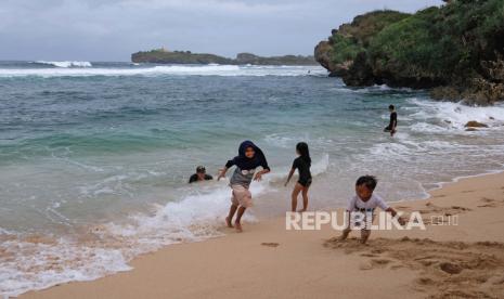 Wisatawan bermain di pantai Sadranan Dusun Pulegundes, Sidoharjo, Tepus, Gunungkidul, DI Yogyakarta, Selasa (7/7/2020). Sejumlah wisata pantai selatan di kabupaten Gunungkidul telah dibuka kembali untuk umum setelah ditutup selama pandemi COVID-19 sejak empat bulan lalu dan mulai ramai dikunjungi wisatawan dari berbagai daerah. 