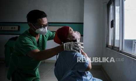 Tenaga kesehatan mengatur tubuh pasien saat akan dilakukan rontgen thorax.