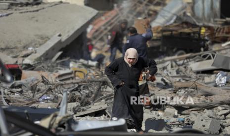 Warga Palestina berjalan melewati kehancuran akibat serangan udara dan darat Israel di Jalur Gaza di Kota Gaza, Sabtu, (10/2/2024).