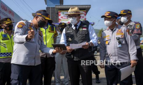 Gubernur Jawa Barat Ridwan Kamil (tengah) mendengarkan pemaparan dari Kadishub Provinsi Jawa Barat A Koswara Hanafi (kiri) saat meninjau Pos Terpadu Limbangan di Limbangan.