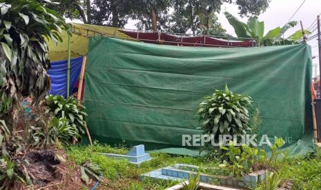 Makam Iim Halimah korban pembunuhan berantai Wowon Cs di TPU Islam, Kampung Saar Mutiara RT 03 RW 07, Desa Karangtanjung, Kecamatan Cililin, Kabupaten Bandung Barat dipasang tenda dan terpal untuk proses pembongkaran, Rabu (25/1/2023). Pembongkaran akan di mulai pukul 11.00 Wib. 