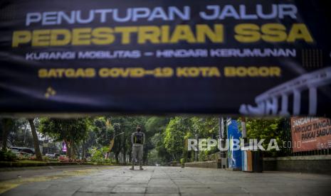 Petugas Satpol PP berjaga saat penutupan jalur pedestrian sistem satu arah (SSA) di Kota Bogor, Jawa Barat, Sabtu (5/2/2022). Jalur pedestrian SSA Kebun Raya Bogor yang biasa digunakan untuk olahraga ditutup hingga Ahad (6/2/2022), sebagai upaya membatasi mobilitas masyarakat seiring bertambahnya kasus Covid-19 di Kota Bogor. 