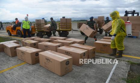 Petugas menyemprotkan disinfektan pada sejumlah kardus berisi Alat Pelindung Diri (APD) dan Masker seusai diturunkan dari  pesawat militer TNI-AU  B 737  tiba di Bandara Sultan Iskandar Muda (SIM) Blang Bintang, Aceh Besar, Aceh, Sabtu (4/4/2020). Satuan Gugus Tugas COVID-19 Pusat mengirimkan Alat Pelindung Diri (APD) sebanyak 3