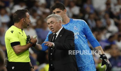 Pelatih Real Madrid Carlo Ancelotti (tengah) berbicara dengan wasit Artur Dias (kiri) dalam laga leg pertama semifinal Liga Champions di Santiago Bernabeu, Madrid, Spanyol, Rabu (10/5/2023) WIB.  