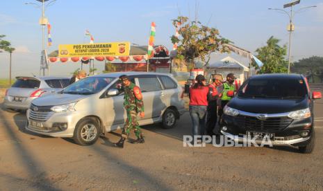 Petugas memeriksa pengendara yang melintas di jalur Pantura perbatasan Indramayu - Cirebon di Kertasmaya, Indramayu, Jawa Barat, Selasa (19/5/2020). Pemkab Indramayu dan Pemkab Cirebon memberlakukan Pembatasan Sosial Berskala Besar (PSBB) diperpanjang selama 10 hari terhitung sejak tanggal 20 Mei hingga 29 Mei 2020