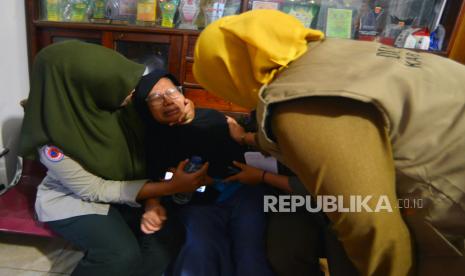 Petugas menenangkan keluarga korban erupsi Gunung Marapi yang histeris menunggu kabar anggota keluarganya di posko bencana Nagari Batu Palano, Agam, Sumatera Barat, Senin (4/12/2023). Basarnas merilis sebanyak 11 orang pendaki meninggal dunia akibat erupsi Gunung Marapi pada Ahad (3/12/2023), keluarga diminta langsung menunggu di RSUD Dr.Achmad Mochtar Bukittinggi untuk identifikasi korban.  