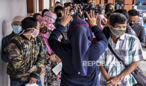 Petugas mengatur antrean warga saat penyaluran bantuan sosial (bansos) Provinsi Jawa Barat Tahap ke-IV di Kantor Pos Bandung, Jalan Asia Afrika, Kota Bandung, Selasa (29/12). Pemerintah Provinsi Jawa Barat mulai mendistribusikan bansos sebesar Rp100 ribu dalam bentuk tunai kepada 1.903.383 Keluarga Rumah Tangga Sasaran (KRTS) penerima bantuan sosial dan ditargetkan selesai pada Rabu (30/12). Foto: Abdan Syakura/Republika