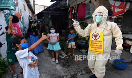 Seorang pemuda Karang Taruna Mojo dengan mengenakan APD melakukan sosialisasi kepada masyarakat tentang pencegahan penyebaran COVID-19 dan masa Pembatasan Sosial Berskala Besar di Surabaya, Jawa Timur, Sabtu (16/5/2020). Dengan sosialisasi tersebut diharapkan masyarakat mematuhi protokol kesehatan untuk melindungi diri dari penularan virus Corona