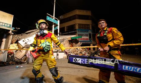  Tim penyelamat membawa peralatan keluar dari puing-puing toko yang runtuh setelah gempa berkekuatan 6,8 melanda Taiwan timur, di Yuli, Kabupaten Hualien, Taiwan, 18 September 2022. Empat orang yang terperangkap di toko yang runtuh telah diselamatkan menurut pemadam kebakaran Taiwan . Serangkaian gempa bumi dan gempa susulan menyebabkan kerusakan struktural kecil dan menggelincirkan kereta, tetapi tidak ada laporan segera tentang kematian.