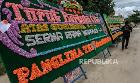 Warga melintas di depan papan bunga ucapan berduka cita yang berjejer di depan tempat tinggal Serma Rama Wahyudi di Kecamatan Tapung, Kabupaten Kampar, Riau, Rabu (24/6/2020). Serma Rama Wahyudi merupakan prajurit TNI yang gugur akibat penyerangan patroli misi perdamaian PBB di Kongo. ANTARA FOTO/Rony Muharrman/foc.