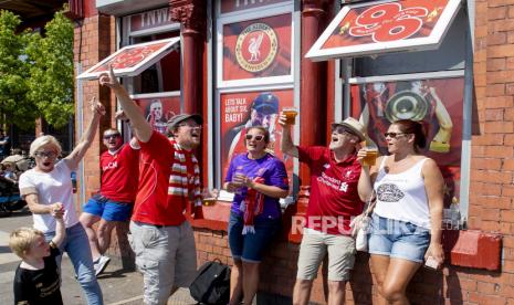  Penggemar Liverpool FC bersulang dan bersorak saat mereka merayakan di luar stadion Anfield di Liverpool, Inggris, 26 Juni 2020. Liverpool telah dinobatkan sebagai juara Liga Premier untuk pertama kalinya dalam tiga dekade setelah Chelsea FC mengalahkan Manchester City FC 2-1 pada malam itu 25 Juni. Kegagalan Man City untuk memenangkan duel krusial ini secara matematis menyerahkan gelar liga Inggris ke klub Liverpudlian yang dipimpin oleh manajer Jerman Juergen Klopp. 