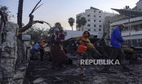 Warga Palestina membawa barang-barang mereka saat meninggalkan rumah sakit al-Ahli, yang mereka gunakan sebagai tempat berlindung, di Kota Gaza, Rabu, 18 Oktober 2023.