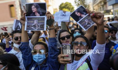 Wanita memegang gambar Mahsa Amini Iran saat mereka meneriakkan slogan-slogan selama protes terhadap kematiannya, di luar konsulat jenderal Iran di Istanbul, Turki, Rabu, 21 September 2022. Protes telah meletus di seluruh Iran dalam beberapa hari terakhir setelah Amini, 22- wanita berusia tahun, meninggal saat ditahan oleh polisi moral karena melanggar aturan berpakaian Islami yang diterapkan secara ketat di negara itu.