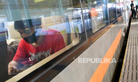 Penumpang mengenakan masker di dalam gerbong kereta api. Ilustrasi