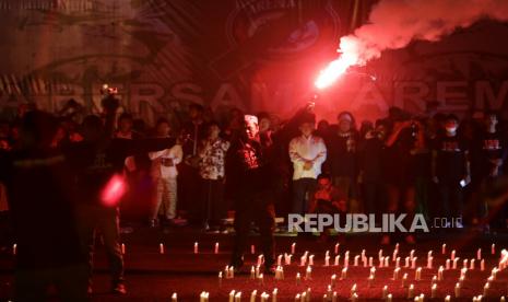 Suporter Arema FC (Aremania) menyalakan flare atau api suar sesaat sebelum mengikuti doa bersama dalam peringatan 40 hari Tragedi  Kanjuruhan di halaman Stadion Kanjuruhan, Malang, Jawa Timur, Rabu (9/11/2022). Doa bersama tersebut untuk mendoakan 135 korban yang meninggal dalam tragedi Kanjuruhan. 