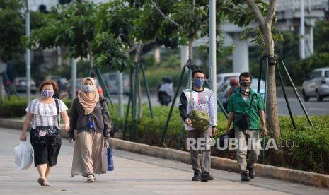 Sejumlah pekerja berjalan di trotoar selepas jam kerja (ilustrasi). Pemerintah mengklarifikasi rencana pelonggaran pembatasan sosial dengan mengizinkan warga dengan usia di bawah 45 tahun untuk kembali bekerja dan beraktivitas normal