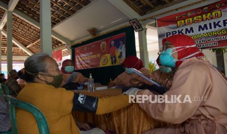 Petugas memeriksa kondisi kesehatan warga sebelum mendapat suntikan vaksin COVID-19 AstraZeneca saat vaksinasi bagi warga lanjut usia (lansia) di balai Kelurahan Munggut, Wungu, Kabupaten Madiun, Jawa Timur, Jumat (21/5/2021). Dinas Kesehatan Kabupaten Madiun menerima sebanyak 40 ribu dosis vaksin COVID-19 AstraZeneca dengan prioritas warga lansia. 