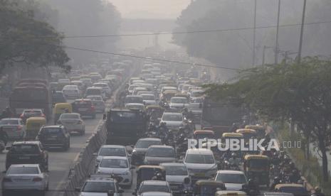  Para komuter berkendara di tengah kabut pagi dan kabut asap beracun di New Delhi, India, Rabu, 17 November 2021. Pemerintah Delhi akan memberikan kompensasi sebesar 5.000 rupee kepada pekerjaan konstruksi yang terdampak oleh penghentian proyek akibat polisi udara. 