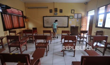 Pegawai sekolah membersihkan ruangan kelas di salah satu SMK di Badung, Bali. Mulai tahun ini kelulusan sekolah tidak ditentukan lewat UN melainkan melalui Asesmen Nasional atau AN.